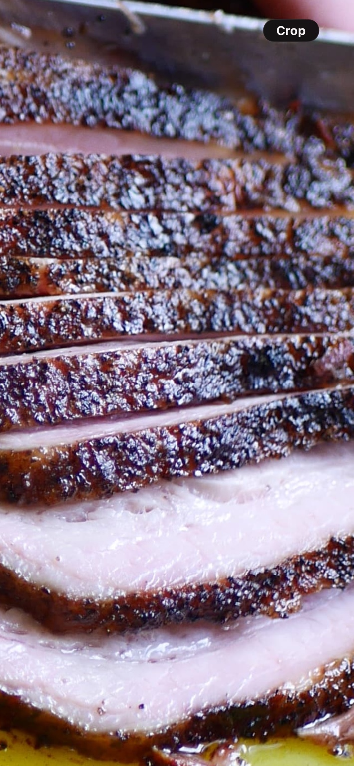 Our sliced smoked pork belly with a dark seasoned bark