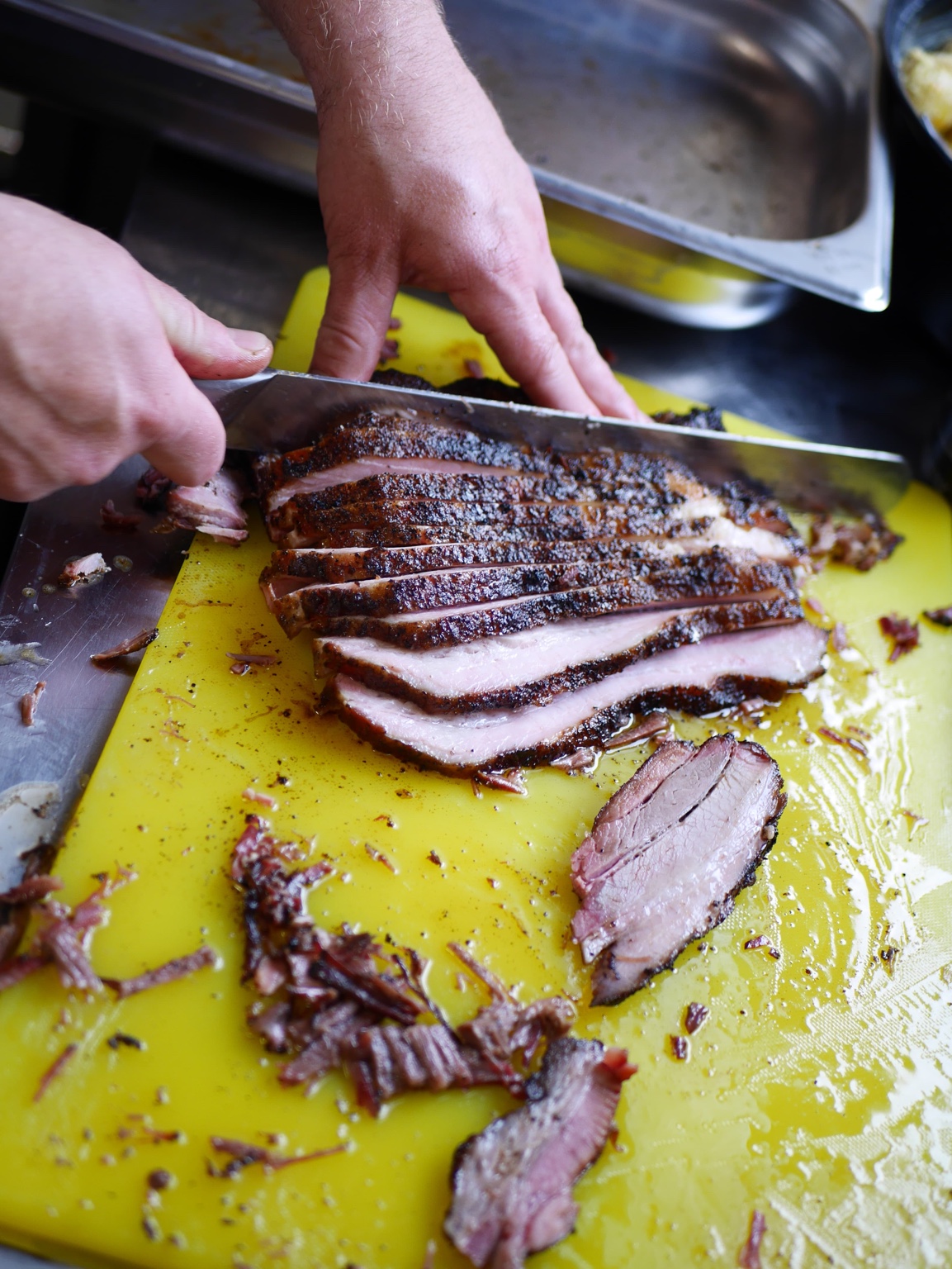 Our smoked pork belly being carved into slices